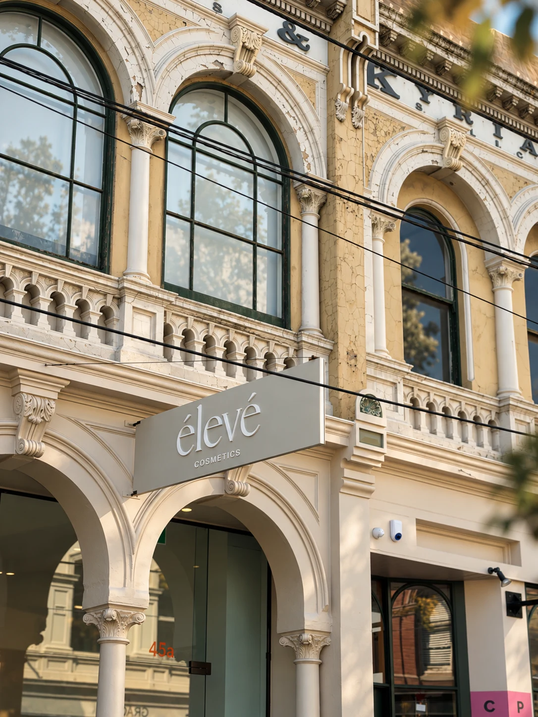 Élevé Cosmetics blade sign projecting from a cream heritage shopfront